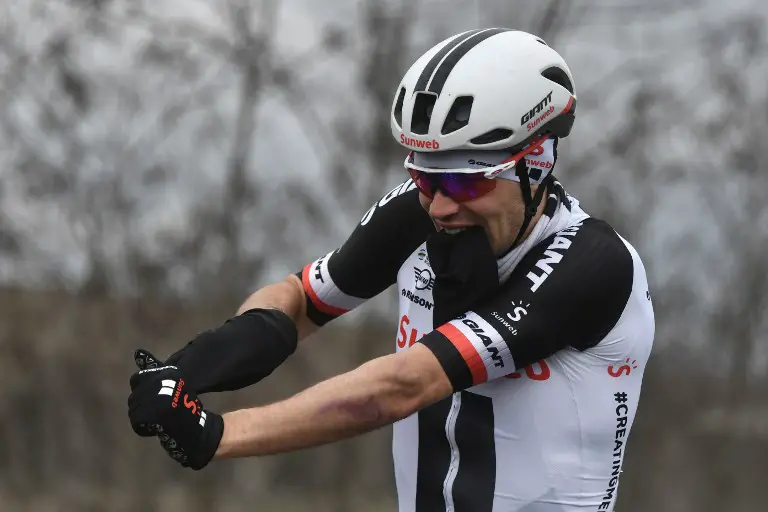Team Sunweb's Dutch rider Tom Dumoulin takes off his warmers during the 109th Milan - San Remo cycling race on March 17, 2018 near Pavia.  / AFP PHOTO / Marco BERTORELLO
