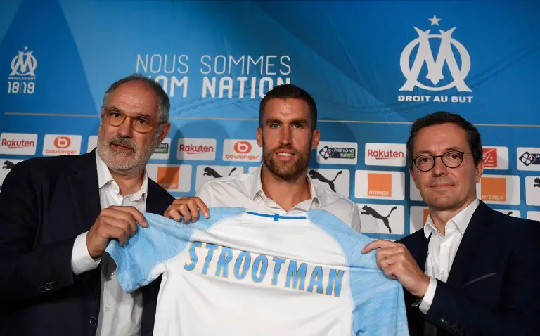 Olympique de Marseille (OM)'s Dutch midfielder Kevin Strootman (C) poses with his new football jersey next to with Olympique de Marseille's sportive manager Andoni Zubizarreta (L) and Olympique de Marseille's (OM) president Jacques-Henri Eyraud (R) during a press conference on August 28, 2018, in Marseille. 
Dutch midfielder Kevin Strootman from the Italian club AS Roma is a new recruit of the OM.  / AFP PHOTO / CHRISTOPHE SIMON