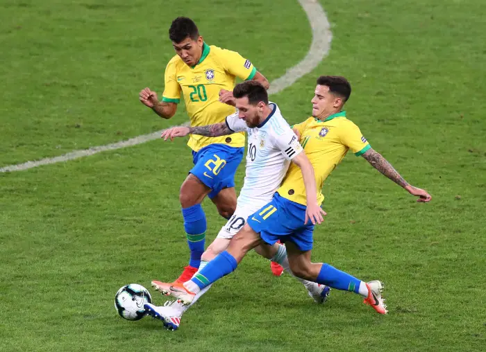 Argentina's Lionel Messi in action with Brazil's Philippe Coutinho and Roberto Firmino