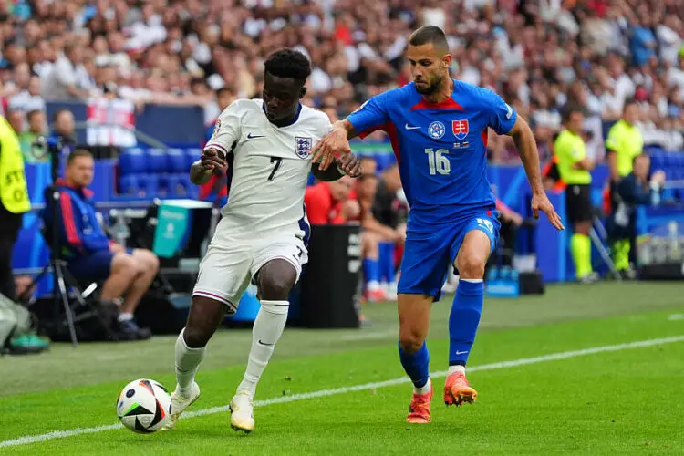 England's Bukayo Saka (left) and Slovakia's David Hancko battle for the ball during the UEFA Euro 2024, round of 16 match at the Arena AufSchalke in Gelsenkirchen, Germany. Picture date: Sunday June 30, 2024.   - Photo by Icon Sport