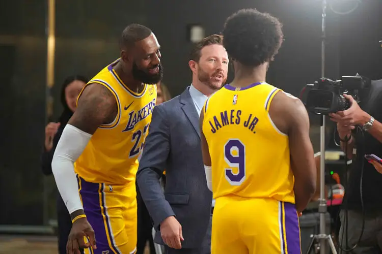 Sep 30, 2024; El Segundo, CA, USA; Los Angeles Lakers forward LeBron James (23) watches as ESPN reporter Dave McMenamin, (center) interviews son Bronny James (9) during media day at the UCLA Health Training Center. Mandatory Credit: Kirby Lee-Imagn Images   - Photo by Icon Sport